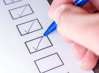 Checking of checklist with blue pen Checking of checklist with blue pen