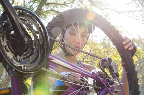 Woman fixing her bike in a forest in the countryside